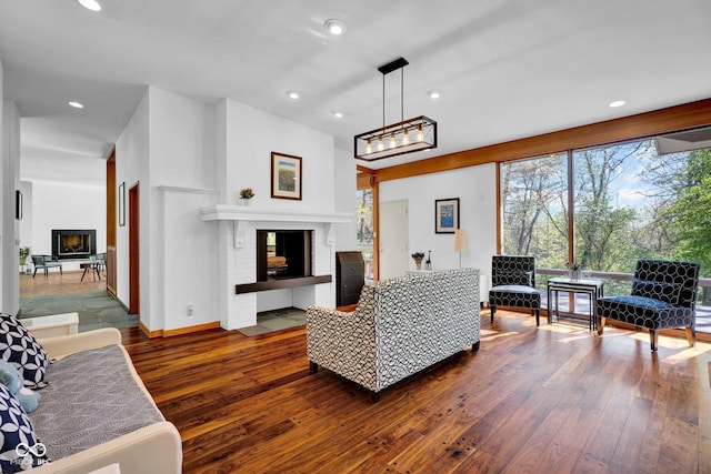 living room featuring recessed lighting, baseboards, a fireplace, and hardwood / wood-style flooring