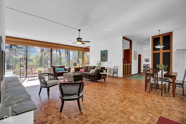 living room with ceiling fan and a high ceiling