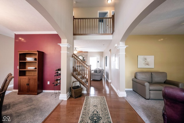entryway featuring baseboards, arched walkways, and decorative columns