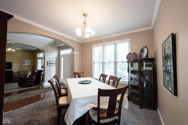 dining area with arched walkways, ornamental molding, baseboards, and dark wood-style floors