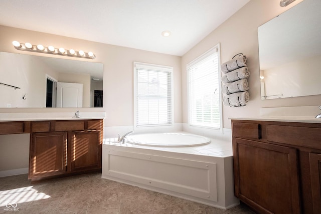 bathroom featuring tile patterned floors, two vanities, a sink, and a bath