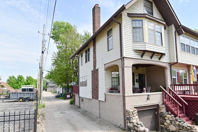 114 E 27th St, Indianapolis, IN 46205 - view of front facade featuring a chimney, a garage, and covered porch