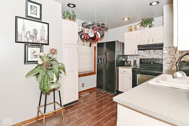 114 E 27th St, Indianapolis, IN 46205 - kitchen with black appliances, under cabinet range hood, white cabinets, tasteful backsplash, and light countertops