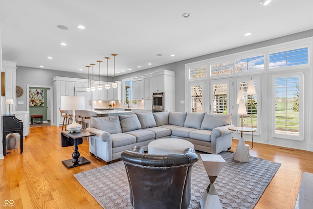 living room with light wood finished floors and recessed lighting