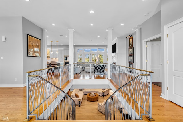 interior space featuring baseboards, recessed lighting, decorative columns, and wood finished floors