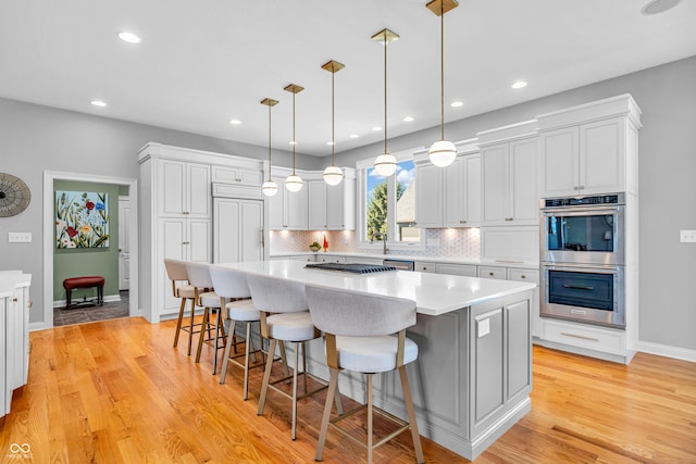 kitchen with a kitchen island, stainless steel appliances, tasteful backsplash, and light countertops