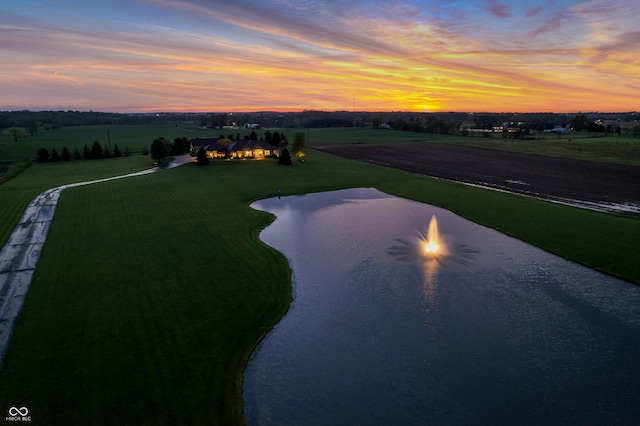 aerial view at dusk with a water view and a rural view