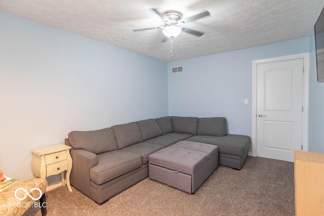 living room with light colored carpet, ceiling fan, visible vents, and a textured ceiling