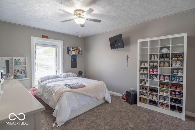 carpeted bedroom featuring baseboards, a ceiling fan, and a textured ceiling