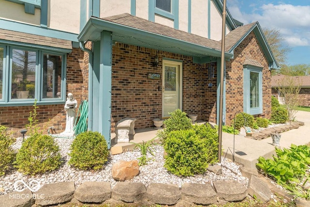entrance to property featuring brick siding and stucco siding