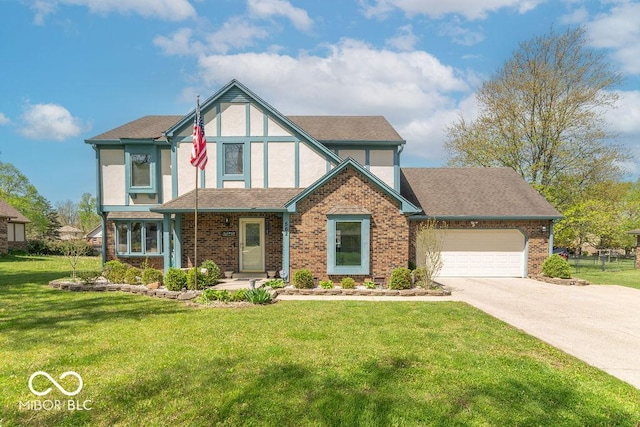 tudor house featuring brick siding, a garage, stucco siding, a front yard, and driveway
