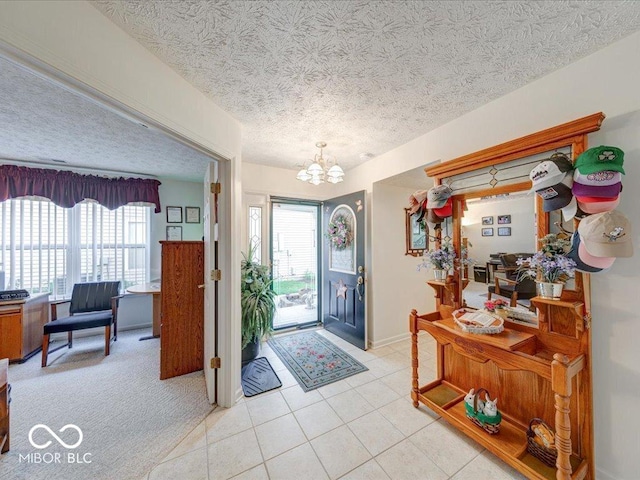 foyer entrance with baseboards, a textured ceiling, light tile patterned flooring, and a chandelier