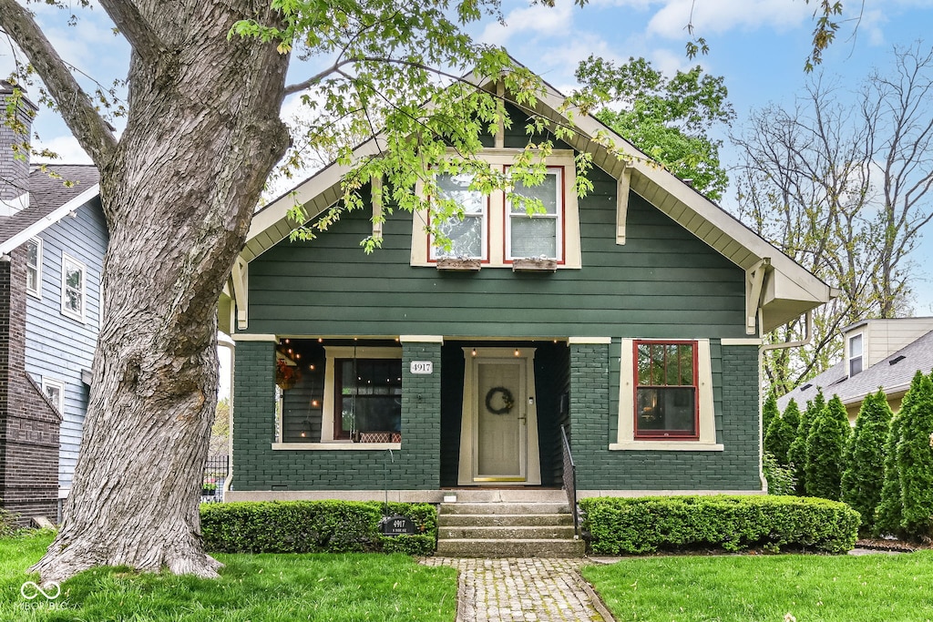 view of front of house with brick siding, a front lawn, and entry steps