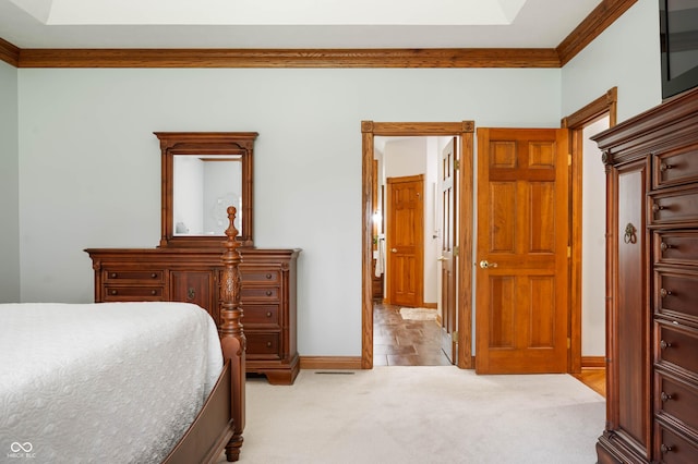 bedroom featuring crown molding, baseboards, and light carpet