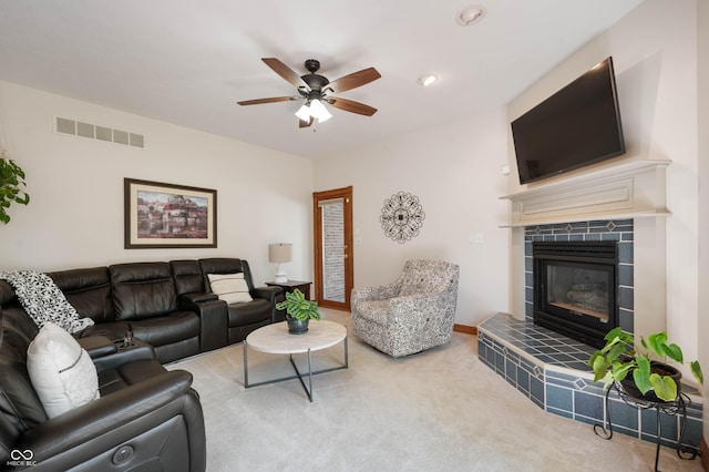 living room featuring visible vents, carpet flooring, ceiling fan, and a tile fireplace