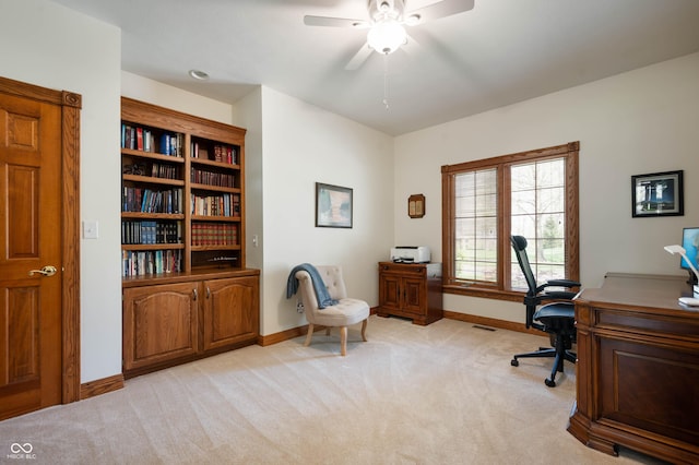 office space with light colored carpet, baseboards, ceiling fan, and visible vents