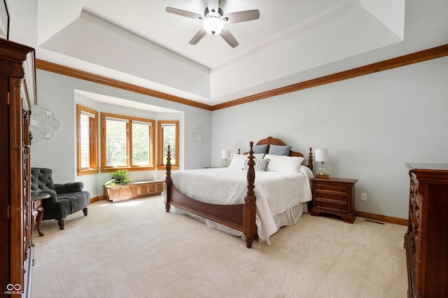 bedroom with baseboards, ceiling fan, light carpet, and a tray ceiling