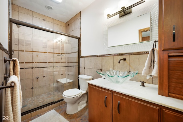 full bath with vanity, a stall shower, toilet, and tile walls