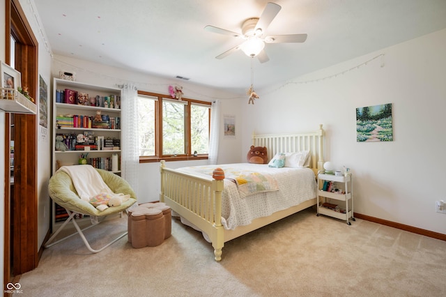 carpeted bedroom with baseboards, a ceiling fan, and visible vents