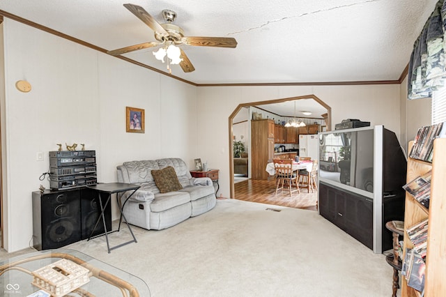 living area featuring a textured ceiling, visible vents, ornamental molding, and ceiling fan with notable chandelier