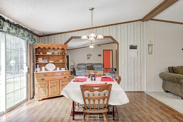 dining room featuring light wood-type flooring, ornamental molding, a textured ceiling, and ceiling fan
