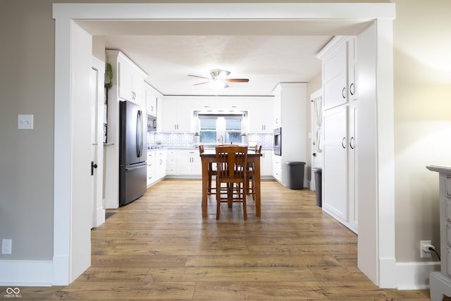 kitchen with a ceiling fan, white cabinetry, appliances with stainless steel finishes, and wood finished floors