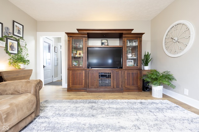 living area featuring light wood-style floors and baseboards