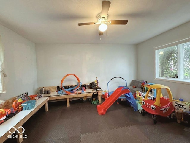 recreation room with ceiling fan and carpet
