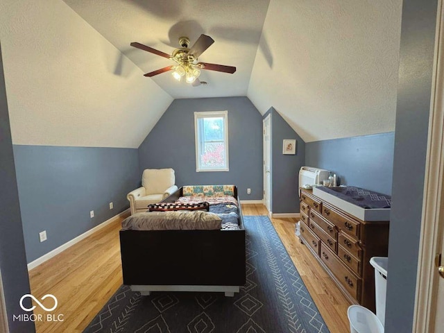bedroom with baseboards, ceiling fan, vaulted ceiling, and wood finished floors