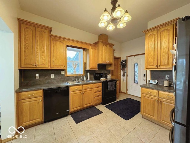 kitchen featuring dark countertops, a chandelier, tasteful backsplash, a sink, and black appliances
