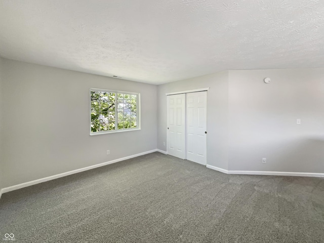 6628 Dunsdin Dr, Plainfield, IN 46168 - unfurnished bedroom with baseboards, dark carpet, and a textured ceiling