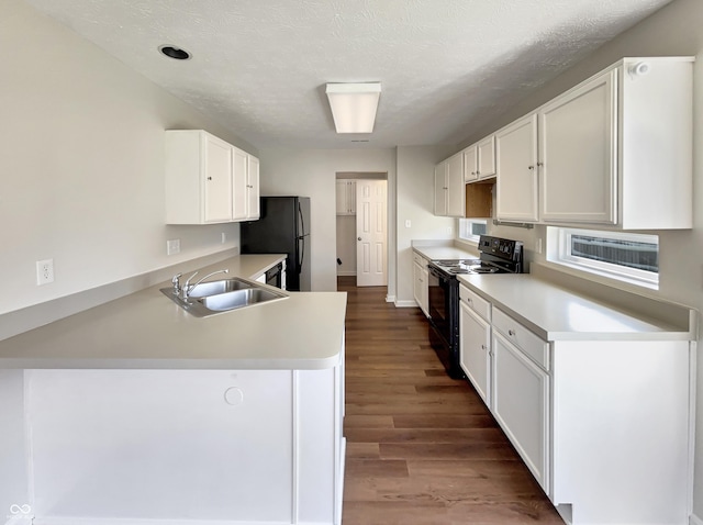 6628 Dunsdin Dr, Plainfield, IN 46168 - kitchen with dark wood-type flooring, light countertops, white cabinetry, a sink, and black appliances