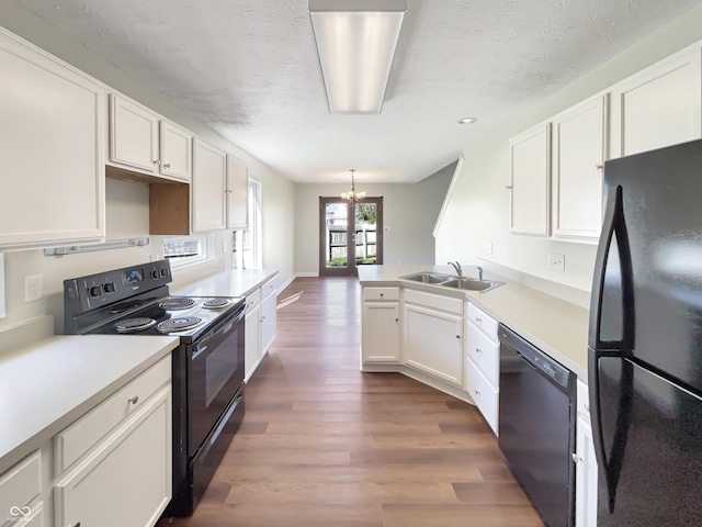 6628 Dunsdin Dr, Plainfield, IN 46168 - kitchen with a sink, white cabinets, black appliances, dark wood-style floors, and a chandelier