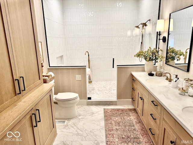 full bath with double vanity, marble finish floor, toilet, a walk in shower, and a sink