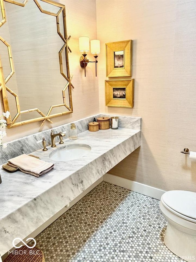 bathroom with baseboards, vanity, and toilet
