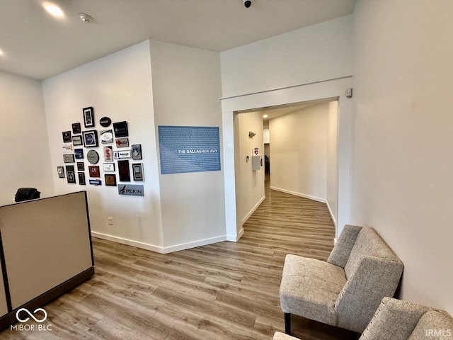 corridor with baseboards and wood finished floors