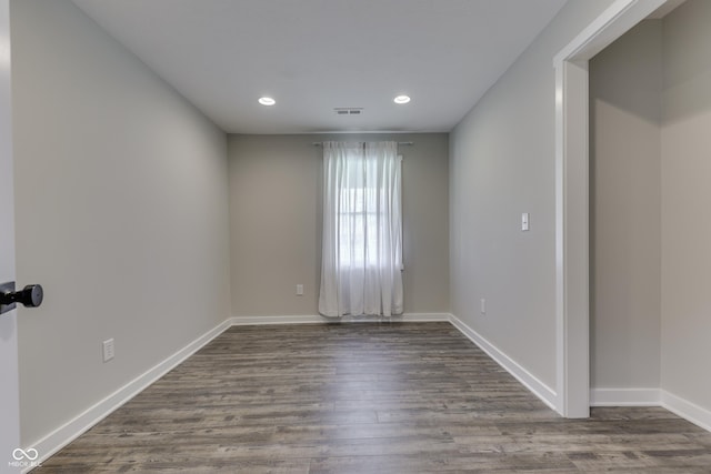 spare room with recessed lighting, dark wood-style flooring, and baseboards