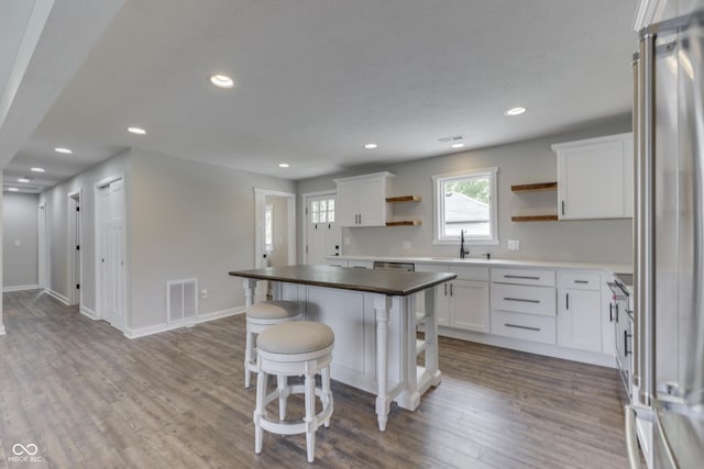 kitchen featuring open shelves, white cabinetry, dark wood-style floors, appliances with stainless steel finishes, and recessed lighting