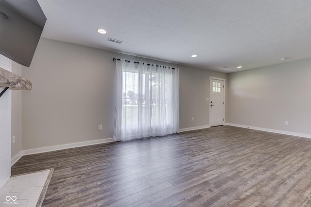 unfurnished living room with wood finished floors, recessed lighting, and baseboards