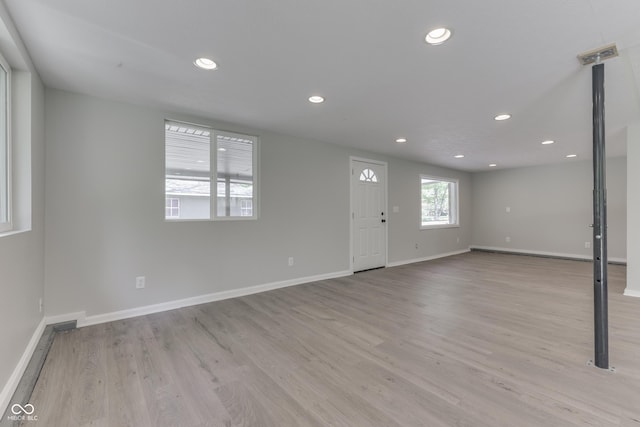 unfurnished living room with recessed lighting, light wood-type flooring, and baseboards