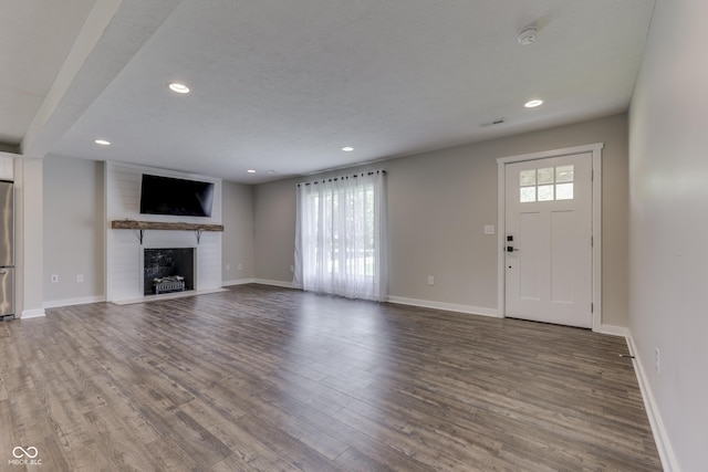 unfurnished living room with a fireplace, wood finished floors, recessed lighting, and baseboards