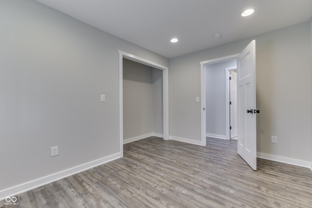 spare room with wood finished floors, baseboards, recessed lighting, and a smoke detector