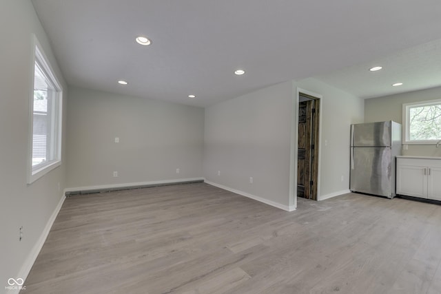 unfurnished room with recessed lighting, light wood finished floors, and baseboards