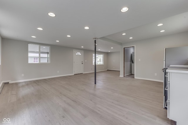 unfurnished living room featuring recessed lighting, baseboards, and light wood-style flooring
