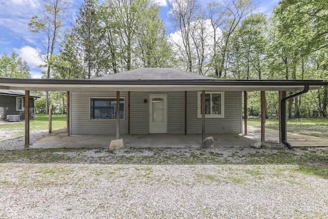 view of front of home featuring driveway, central AC unit, and a shingled roof