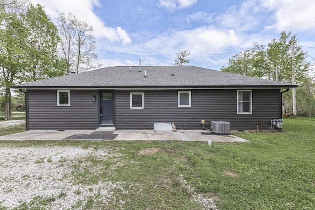 back of property with a patio area, a lawn, roof with shingles, and cooling unit
