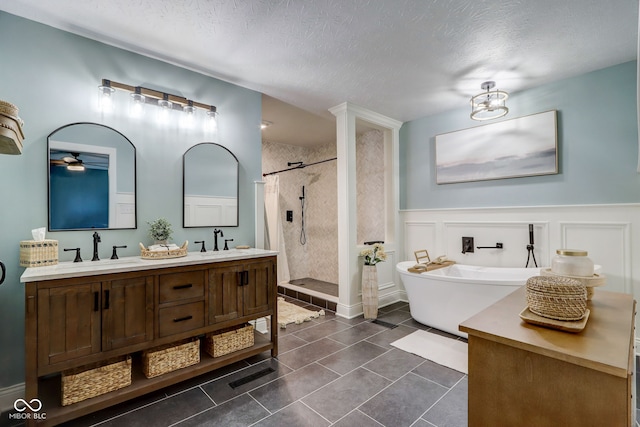 bathroom featuring a soaking tub, a shower stall, a sink, and tile patterned flooring