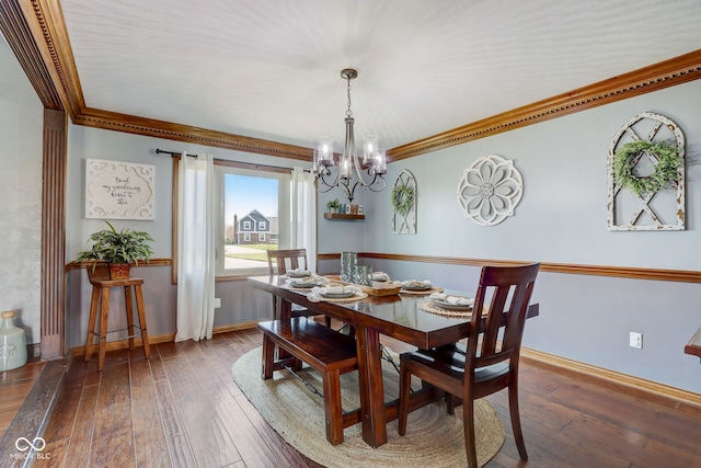 dining area with baseboards, ornamental molding, and a chandelier