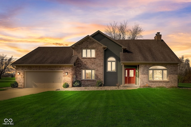 view of front of home featuring a yard, brick siding, a chimney, and a garage