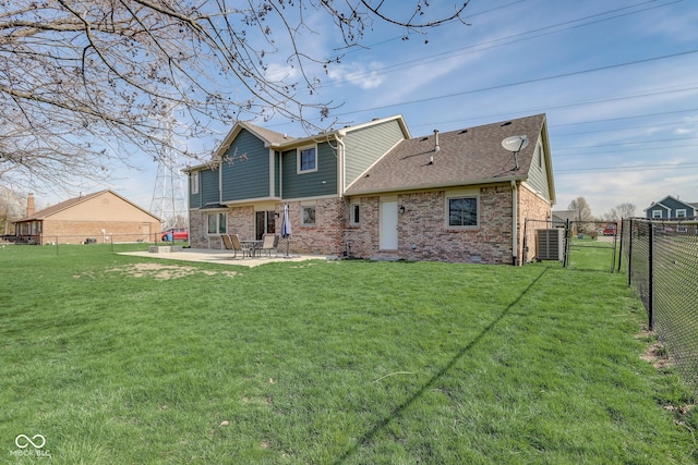 rear view of house with a gate, a patio area, brick siding, a fenced backyard, and a yard